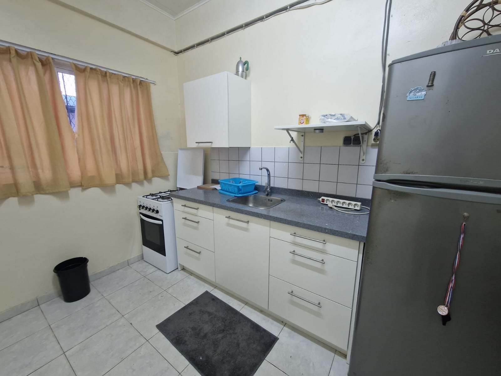 Kitchenette with stove, sink and fridge